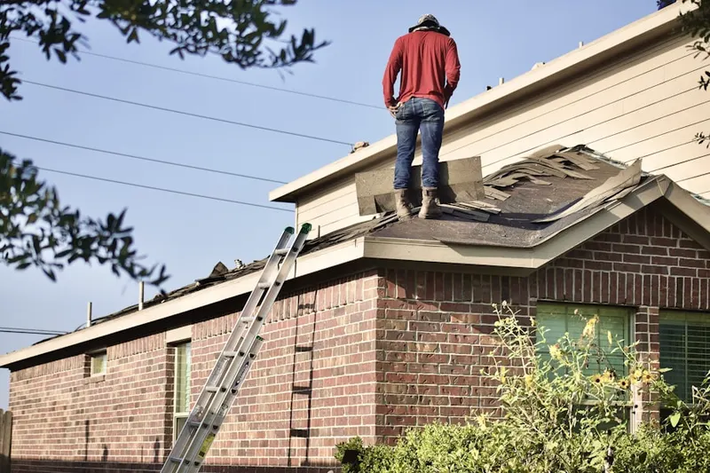 Professional roofer working on a residential roof in Galeville